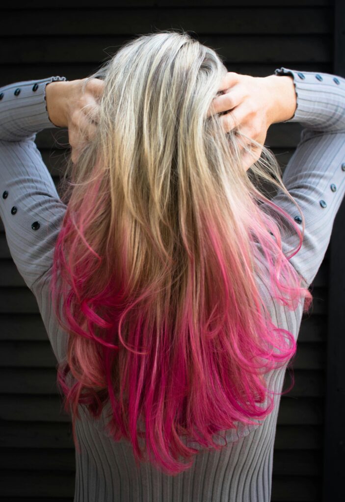 pexels-photo-1321916-1321916 Woman in Gray Long-sleeved Top Holding Hair
